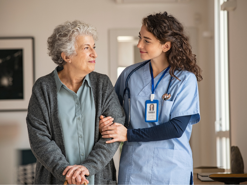 senior and caregiver similing at eachother
