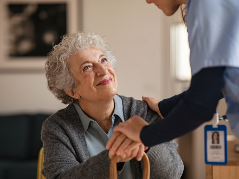 senior similing at caregiver while she's sitting down