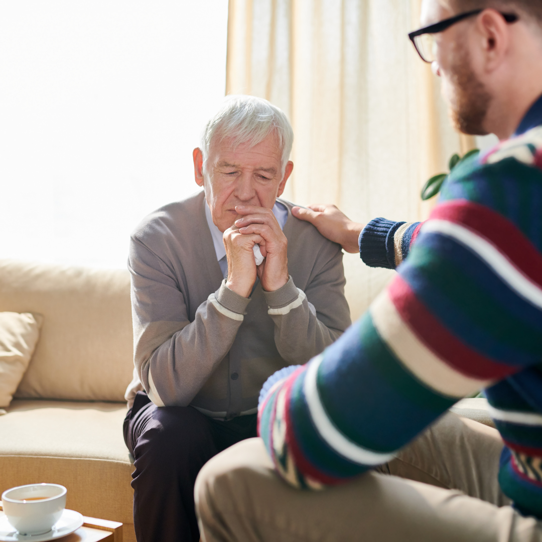 Concerned adult son talking to senior father
